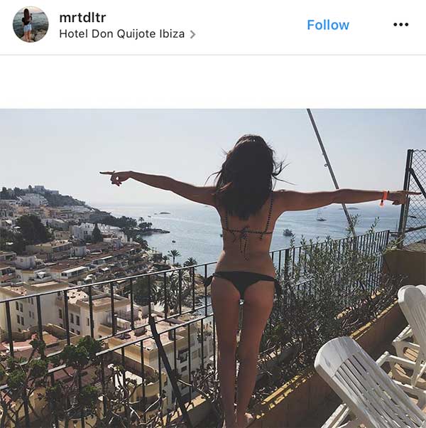 Gostosa de bikini admirando a vista do hotel em Ibiza